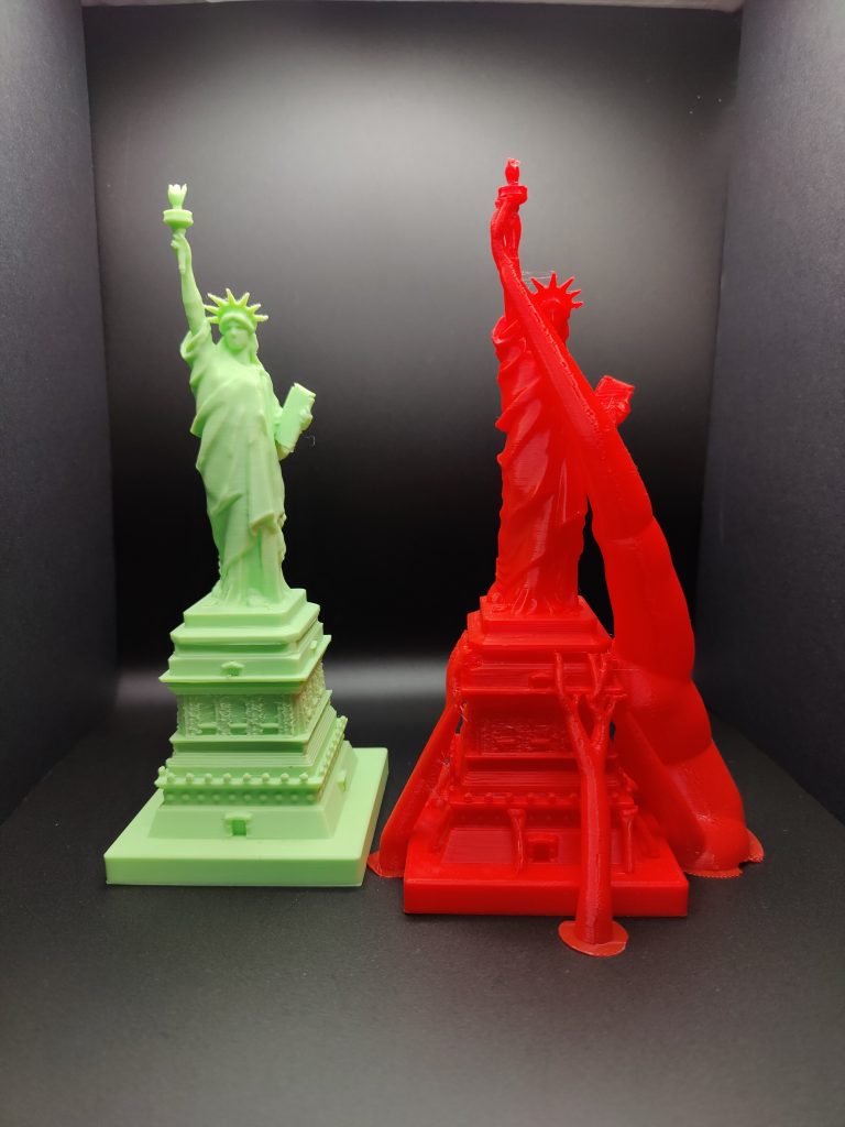 Two 3D printed models of the Statue of Liberty. On the left is a model without supports. On the right is a model with supports.